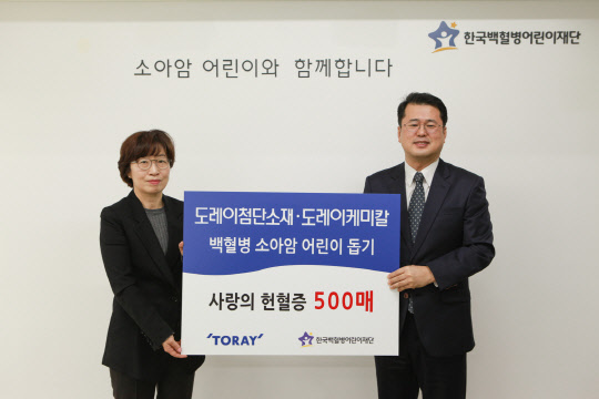 14일 김은주 도레이첨단소재 상무(왼쪽)가 서선원 헌혈증 500매를 한국백혈병어린이재단 사무처장에게 전달하고 있다. 도레이첨단소재 제공